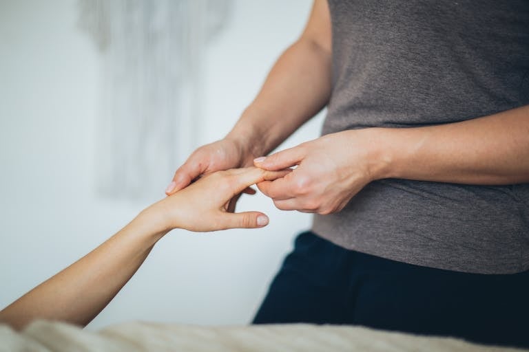Close-up of a hand massage in a calming spa environment.